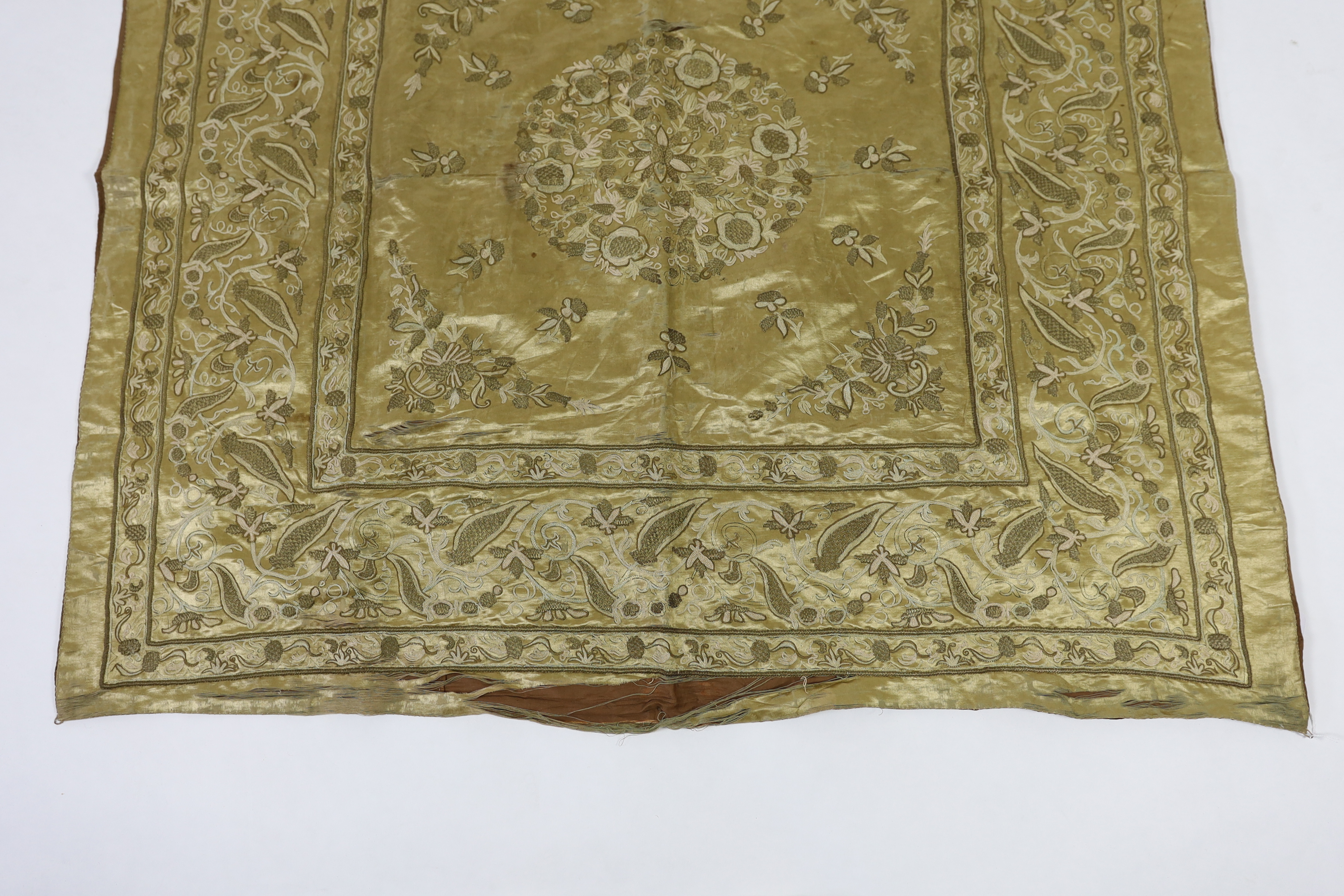 A late 19th century Turkish metallic thread and chain stitch silk satin cover, embroidered with a central cartouche of flowers and print, with rows of various borders with similar embroidery, 123 x 116cm